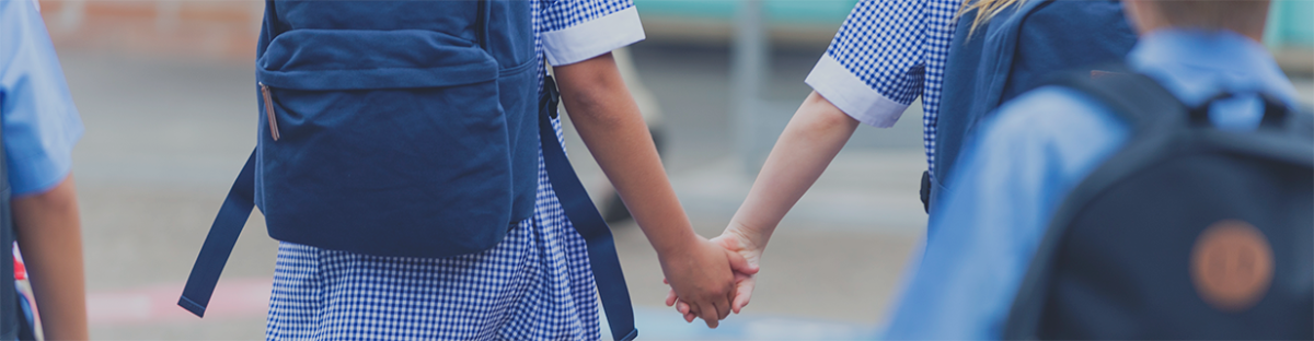 School children holding hands in school 